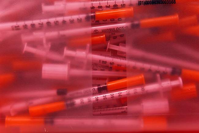 A disposal container is filled with hypodermic needles that were exchanged at a clinic is seen Jan. 20, 2012, in Portland, Maine.