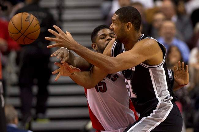 San Antonio Spurs forward Tim Duncan, front, has the ball knocked loose by Toronto Raptors forward Amir Johnson during the first half of an NBA basketball game in Toronto on Tuesday, Dec. 10, 2013.