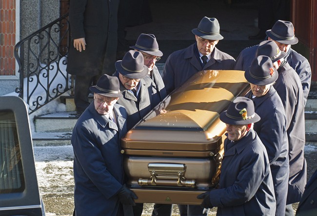 Pallbearers carry the coffin of reputed mafia boss Vito Rizzuto from a church in Montreal, Monday, Dec. 30, 2013, following his funeral.