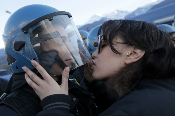 Italian Demonstrator Nina De Ciffre kisses a riot police officer on November 16,