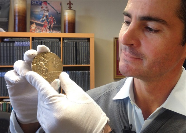 In this Nov. 19, 2013 photo, Dan Imler of SCP Auctions shows Jessie Owens gold medal from the 1936 Olympics at the SCP Auctions in Laguna Nigel, Calif. (AP Photo/Raquel Dillon).