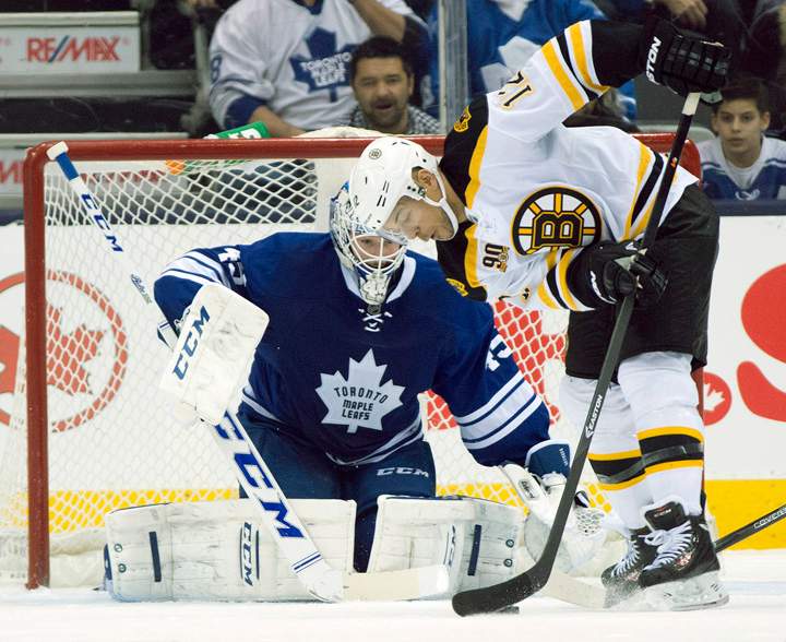 Toronto Maple Leafs goaltender Jonathan Bernier keeps a close eye on the puck as Boston Bruins right winger Jarome Iginla (12) tries to get a shot off during second period NHL action in Toronto on Sunday December 8, 2013. 