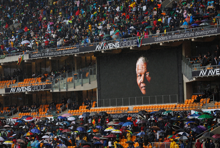 The face of Nelson Mandela is shown on a large billboard in the stands at the memorial service for former South African President Nelson Mandela at the FNB Stadium in the Johannesburg, South Africa township of Soweto, Tuesday Dec. 10, 2013.