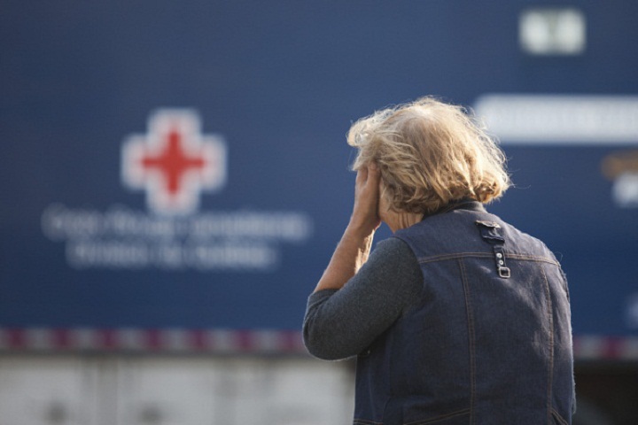 A concerned resident waits July 7, 2013 near an aid station set up after a freight train loaded with oil derailed in Lac-Megantic, Que.