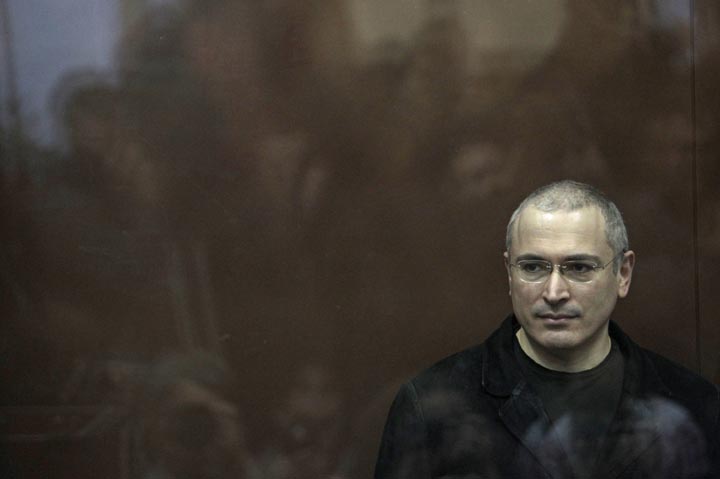 In this Monday, Dec. 27, 2010 file photo former oil tycoon Mikhail Khodorkovsky stands behind glass at a court room in Moscow, Russia. 