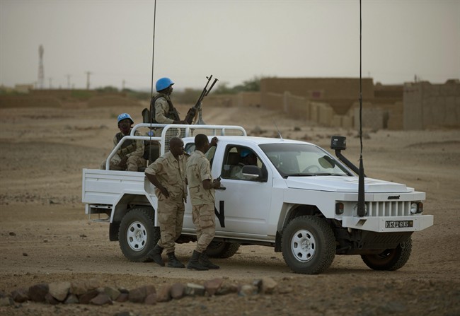 In this July 28, 2013 photo, United Nations peacekeepers stand guard at a polling station, during presidential elections in Kidal, Mali. 