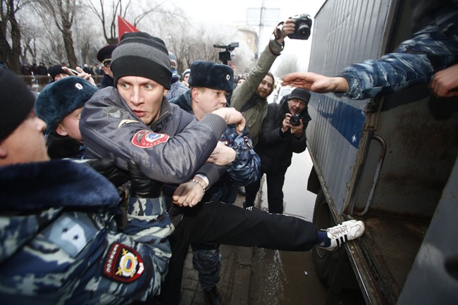 Police officers detain people who gathered for an unsanctioned event in downtown Volgograd, Russia, Monday, Dec. 30, 2013.