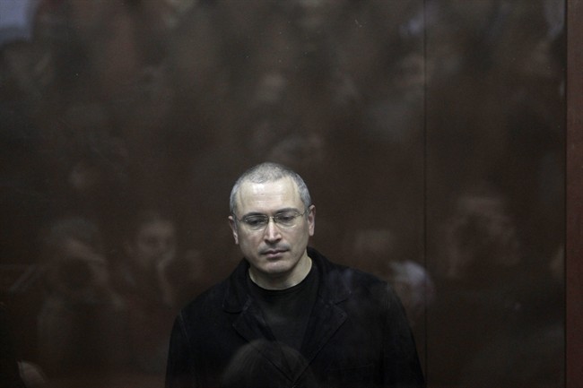 In this Monday, Dec. 27, 2010 file photo former oil tycoon Mikhail Khodorkovsky stands behind glass at a court room in Moscow, Russia.