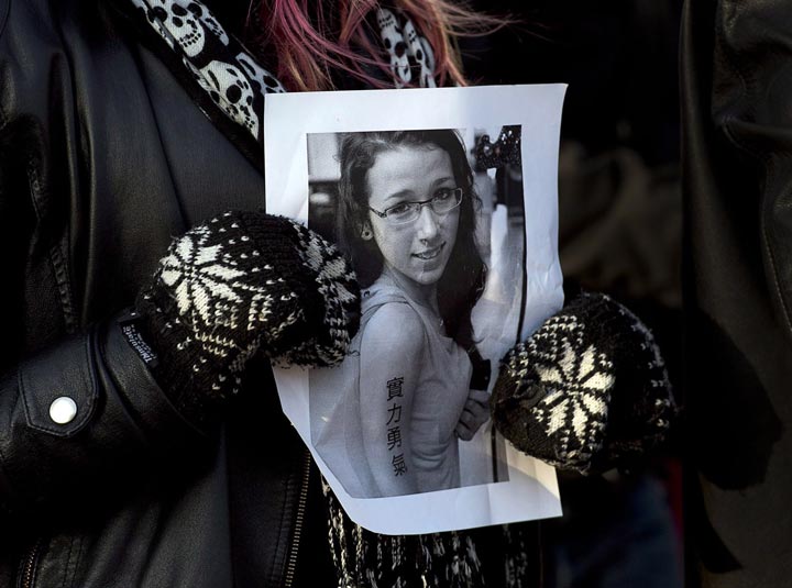 A woman holds a photo as people attend a community vigil to remember Rehtaeh Parsons at Victoria Park in Halifax.