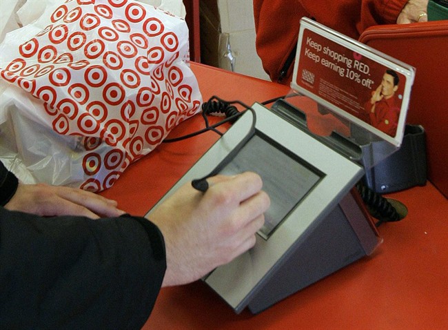 A customer signs his credit card receipt at a Target store.