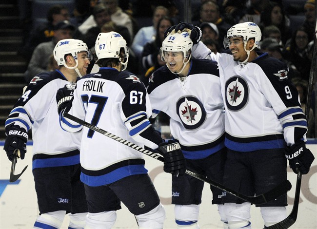 Winnipeg Jets' Grant Clitsome, left, Michael Frolik (67), and Evander Kane (9) celebrate with Mark Scheifele, second from right, after Scheifele scored his second goal of the second period against the Buffalo Sabres in Buffalo, N.Y., Tuesday.