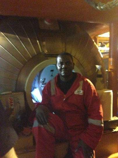Harrison Okene sits outside a decompression chamber after being rescued from a capsized tugboat, off the coast of Nigeria, in May. (Photo released by DCN Diving)