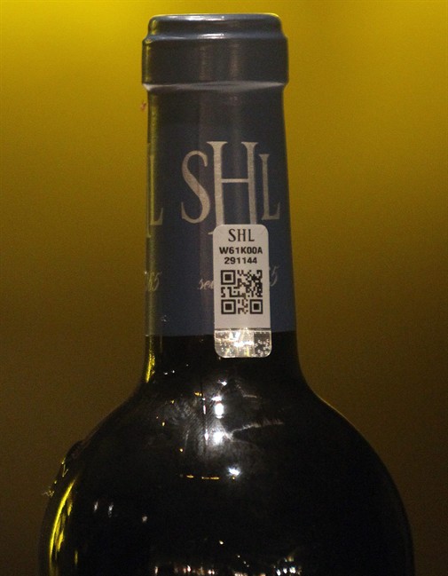 In this photo dated Wednesday, Nov. 13, 2013, an anti-fraud label is stick on a bottle of red wine Chateau Smith Haut Lafitte in Martillac, near Bordeaux, southwestern France. 