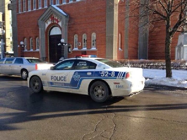 Montreal police cruise past the church in Little Italy where the funeral was held for reputed Mafia boss Vito Rizzuto on December 30, 2013.
