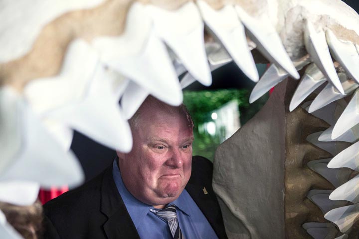 Toronto Mayor Rob Ford poses for a photo opportunity with other dignitaries in shark  jaws at the opening of Ripley's Aquarium of Canada in Toronto on Wednesday, October 16, 2013. 