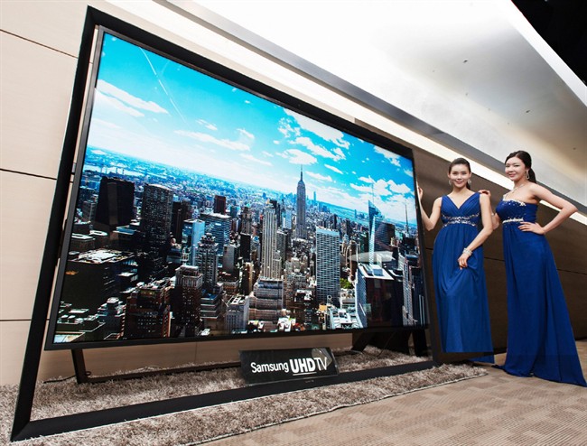 Models pose with a Samsung Electronics 110-inch UHD TV, set to debut at CES this week.