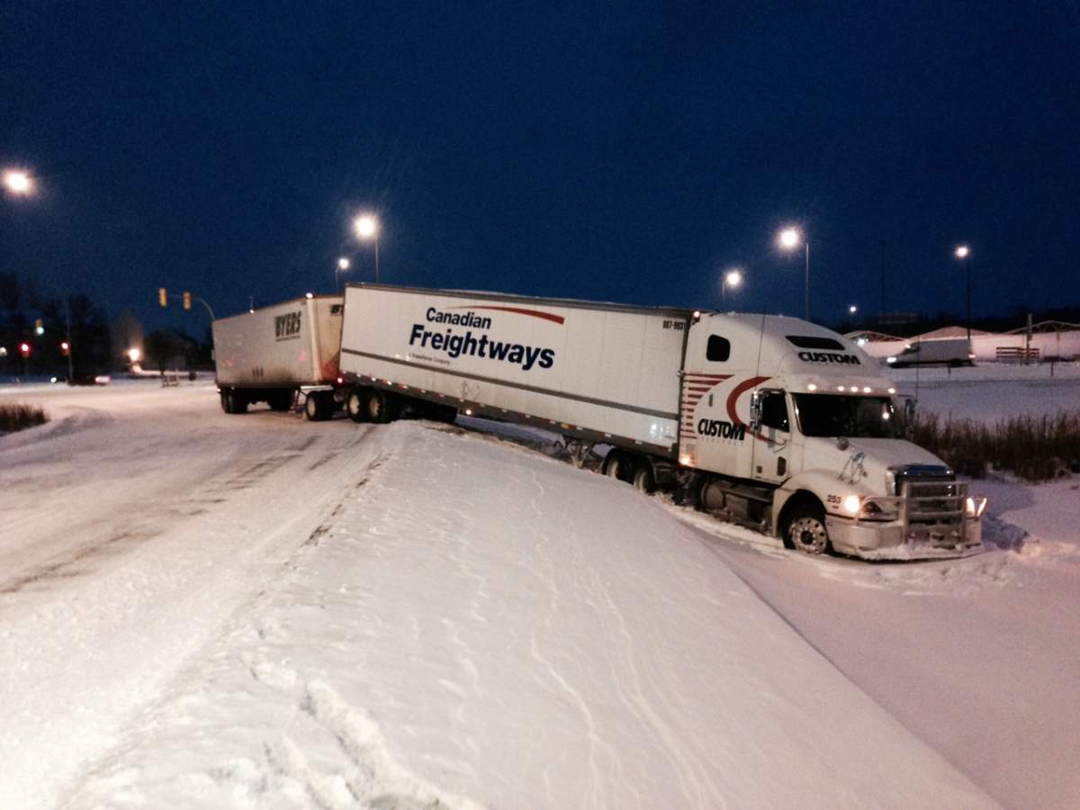 A semi-trailer truck sits part way into a ditch along the westbound Pembina Highway off-ramp onto the Perimeter on Thursday morning.