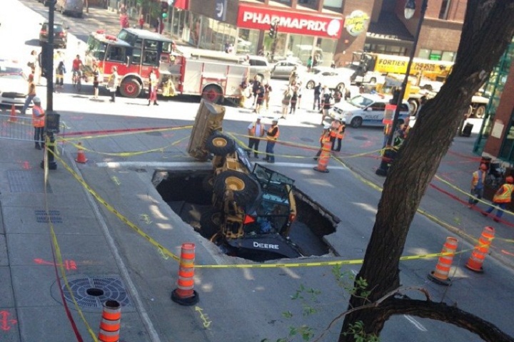 A backhoe was swallowed by a sinkhole in downtown Montreal on August 5, 2013.