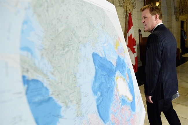 Foreign Affairs Minister John Baird walks past a map of the Arctic at a news conference on Canada's Arctic claim in Ottawa, Monday, Dec.9, 2013.