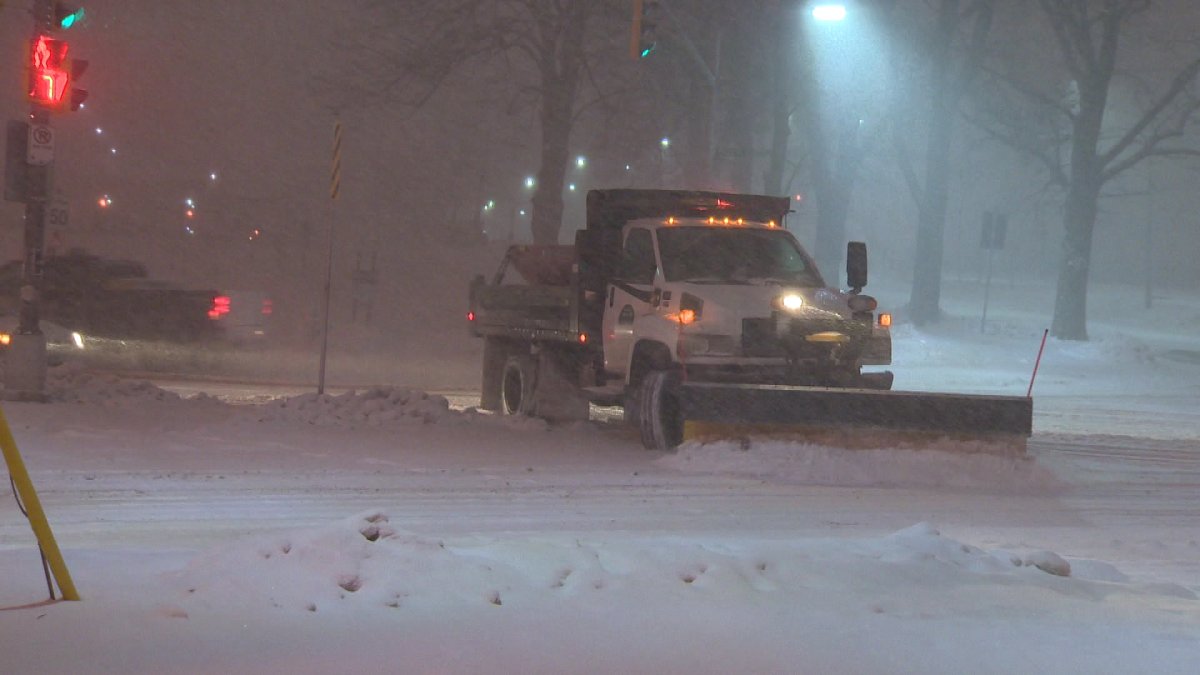 A snow plow starts to tackle fallen snow on the streets of Halifax.
