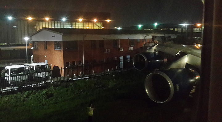 In this photo taken Sunday, Dec. 22, 2013, the wing of a British Airways Boeing 747-400 passenger aircraft is seen after it clipped a building, slightly injuring four members of ground staff, as it made its way to the runway for take off for London, at OR Tambo International Airport, Johannesburg, South Africa. The Airports Company South Africa said Monday, Dec. 23 that none of the 180 passengers on board were injured in the accident which occurred late Sunday night.