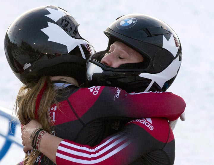 Kaillie Humphries, right, and Heather Moyes hug after winning the women's World Cup bobsled race in Calgary, Alta., Saturday, November 30, 2013.
