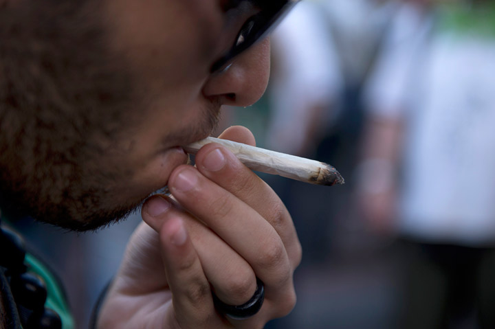 A man smokes a joint during a march for the legalization of marijuana towards the Legislative Palace in Montevideo.