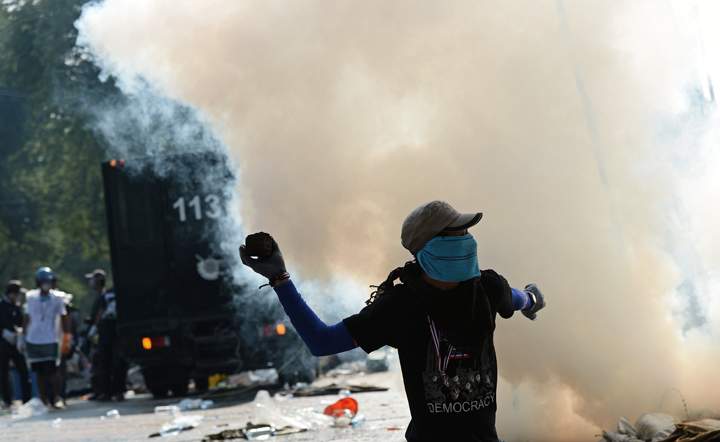 A Thai anti-government protester throws a paving stone to the police during an ongoing rally outside Government House in Bangkok on December 2, 2013.