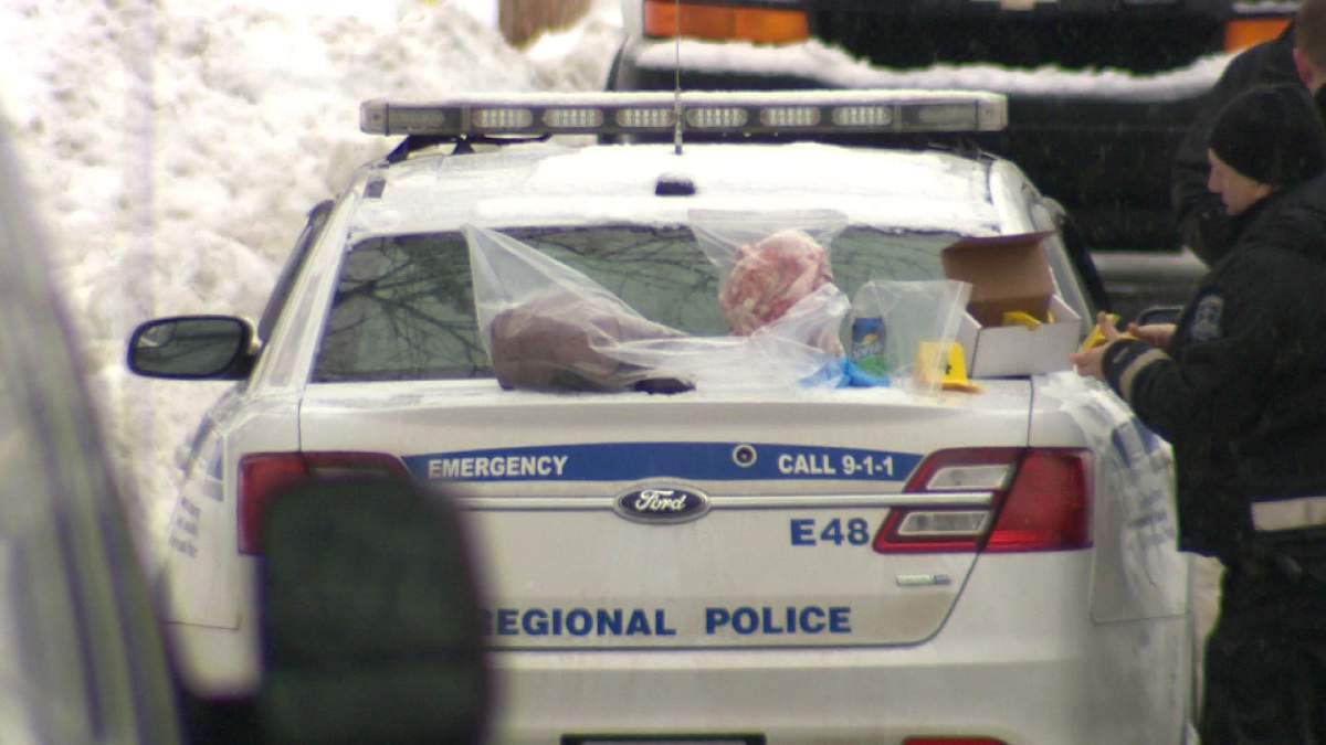 Bags of evidence are placed on top of a police car.