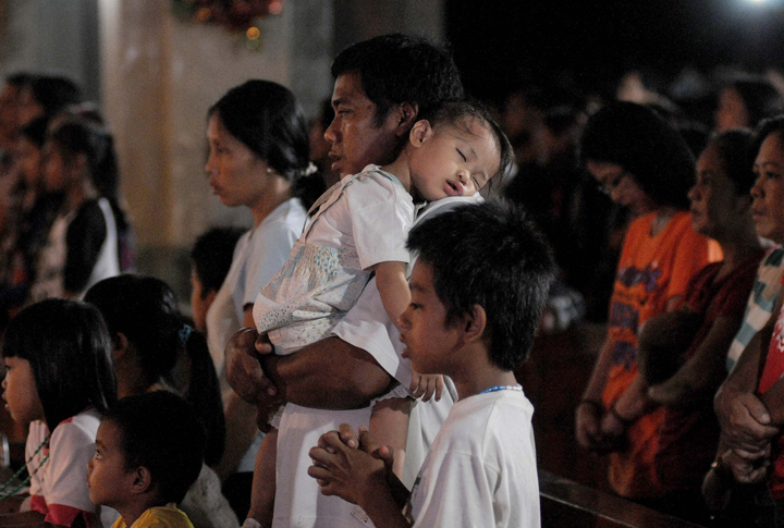 Typhoon survivors attend the final dawn mass on Christmas eve at a church in typhoon-hit Tacloban, Philippines, December 24, 2013.