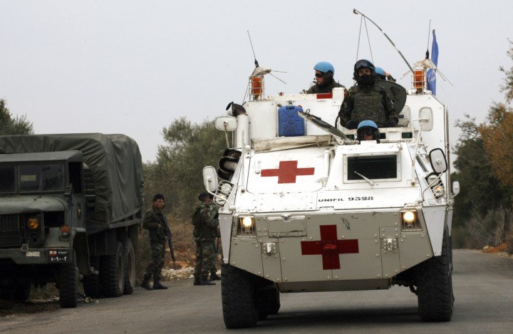 Lebanese soldiers look on , as a United Nations UNIFIL medical armored vehicle patrols the area after 20 the shells were fired by the Israeli army into southern Lebanon, near Rashaya al-Fukhar on December 29, 2013, without causing any damage. 