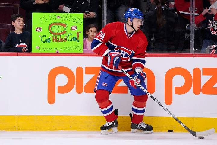 Alexei Emelin #74 of the Montreal Canadiens skates during the warm up while young fans hold up a sign asking for pucks prior to the NHL game against the New York Rangers at the Bell Centre on March 30, 2013.