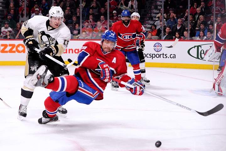 James Neal #18 of the Pittsburgh Penguins hooks Andrei Markov #79 of the Montreal Canadiens in the final minute of regulation during the NHL game at the Bell Centre on November 23, 2013.
