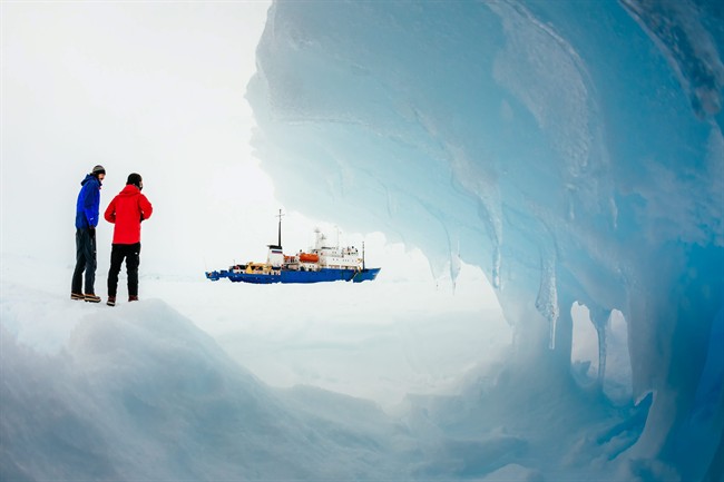 In this Tuesday, Dec. 31, 2013 image provided by Australasian Antarctic Expedition/Footloose Fotography, passengers from the Russian ship MV Akademik Shokalskiy trapped in the ice 1,500 nautical miles south of Hobart, Australia, walk around the ice. 