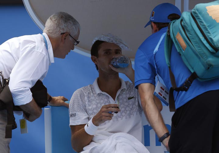 Damir Dzumhur talks with medical staff between games during his third round match against Tomas Berdych of the Czech Republic at the Australian Open tennis championship in Melbourne, Australia, Friday, Jan. 17, 2014.