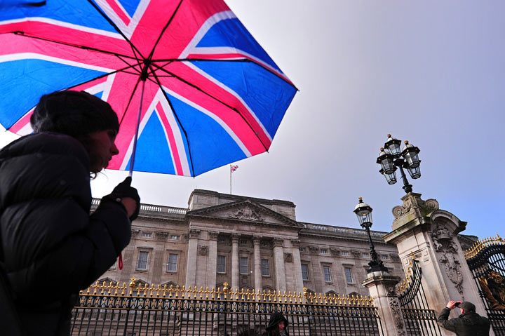 A tourist walks past Buckingham Palace in central London, on January 28, 2014.