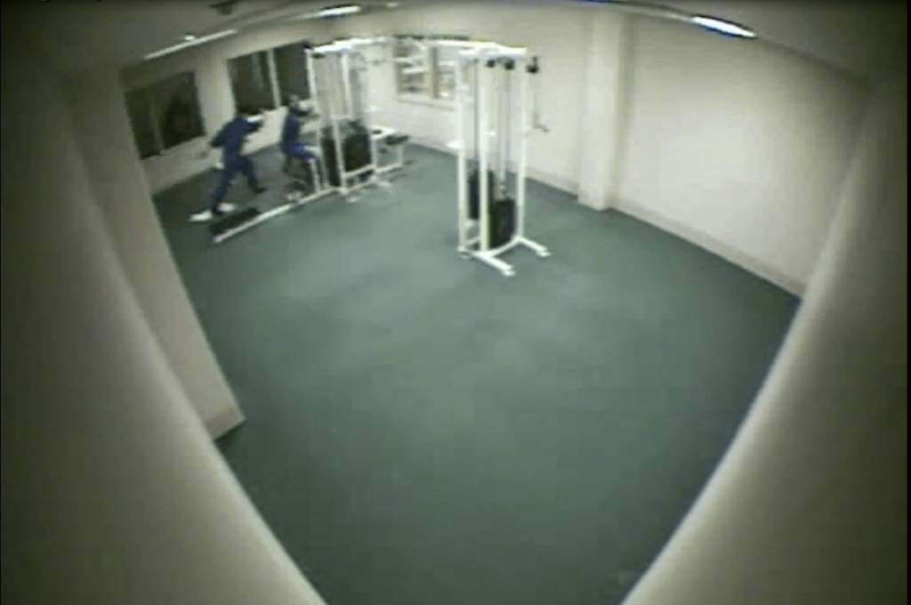 A still from surveillance video that shows an inmate at the Calgary Remand Centre being attacked by two men in the weight room.