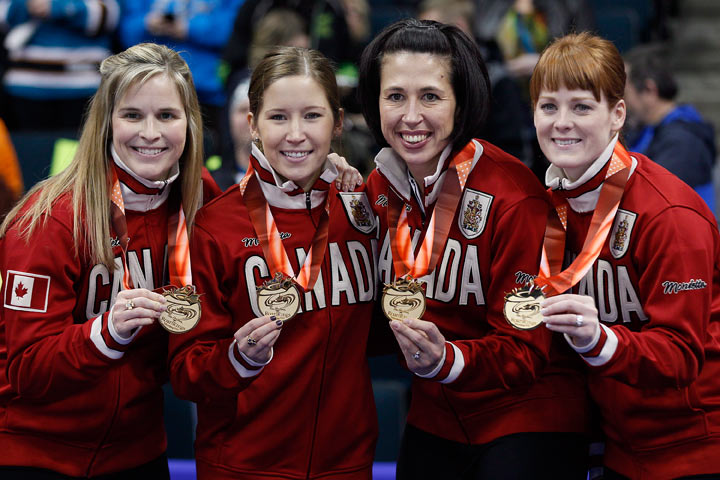 Skip Jennifer Jones, Kaitlyn Lawes, Jill Officer and Dawn McEwen celebrate after putting on their Canada jersey after defeating Sherry Middaugh in the women's final at the 2013 Roar of the Rings Canadian Olympic Curling Trials in Winnipeg, Saturday, December 7, 2013.