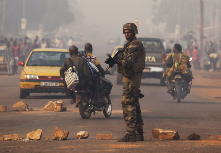 A French soldier waves through traffic as he mans a roadblock in the Miskine neighborhood of Bangui, Central African Republic.