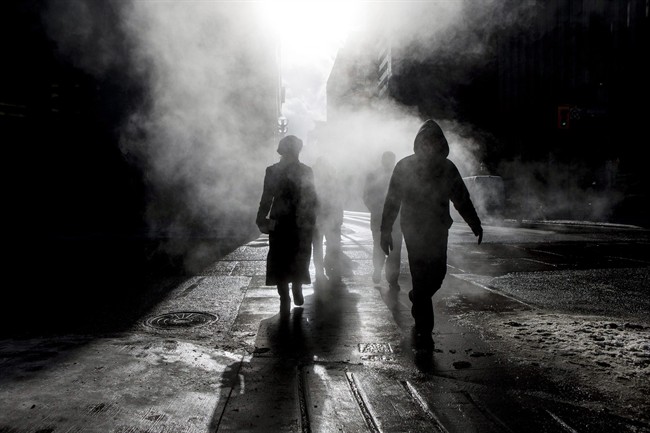 Pedestrians cross an intersection near a subway steam vent in downtown Toronto in Jan. 2014. Environment Canada has issued an extreme cold alert for the city, with wind chills expected to make it feel as cold as -40 C in Toronto.