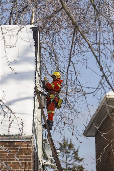 A Toronto Hydro crew member works to restore power to a house in a Scarborough neighbourhood on Friday, December 27, 2013.