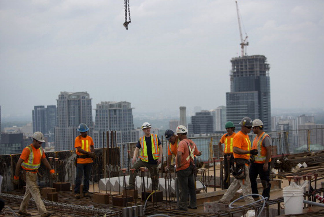 Construction workers work on a condominium development this past summer. 
