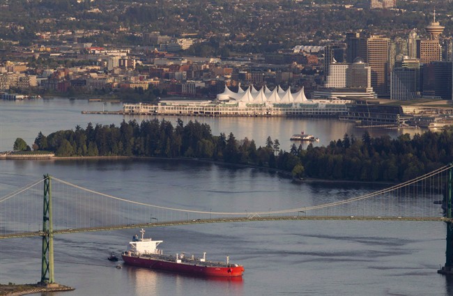 A oil tanker is guided by tug boats as it goes under the Lions Gate Bridge at the mouth of Vancouver Harbour on May 5, 2012. THE CANADIAN PRESS/Jonathan Hayward.