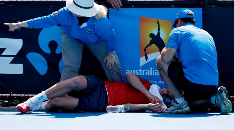 Frank Dancevic of Canada lies on the court after collapsing during his first round match against Benoit Paire of France as temperatures topped at 43 C (108 F) at the Australian Open tennis championship in Melbourne, Australia, Tuesday, Jan. 14, 2014. (AP Photo/Aijaz Rahi)