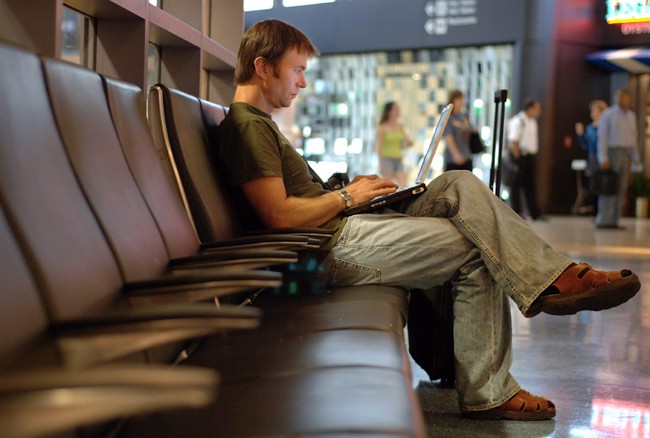 A Canadian traveller works on his laptop in Boston. Canadians say they mostly trust the government to balance security and privacy.