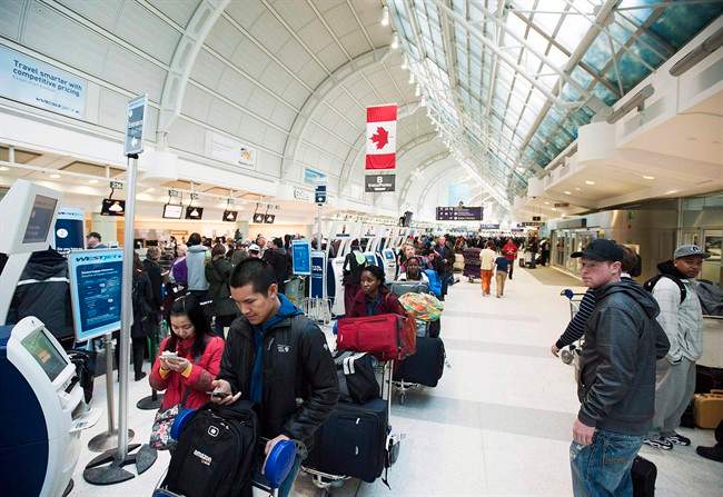 Passengers line-up during flight delays at Pearson International Airport in Toronto on Tuesday January 7, 2014. THE CANADIAN PRESS/Aaron Vincent Elkaim