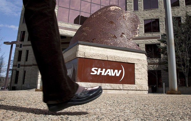 A pedestrian walks past the headquarters of Shaw Communications in Calgary, April 13, 2011. THE CANADIAN PRESS/Jeff McIntosh.