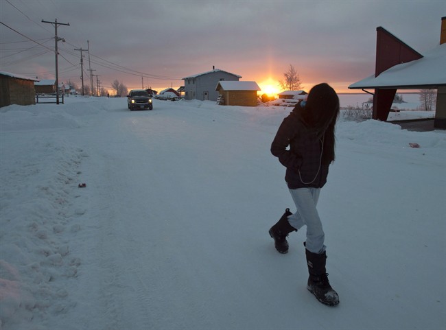 A girl walks along the streets at sunrise December 18, 2012, on the Fort Hope First Nation, Ont.