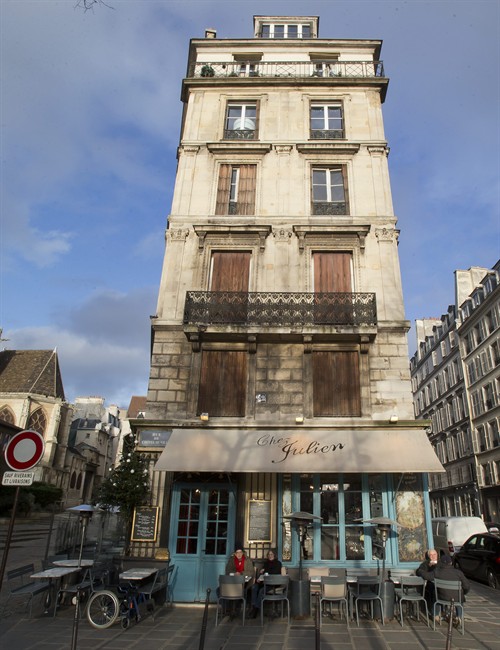 In this Wednesday, Jan. 8, 2014 photo, an elderly couple sits outside the Chez Julien restaurant at the the Marais District in Paris. You can start your walk on the Rue Saint-Jacques, which begins across the street from the restaurant Les Papilles and will take you all the way to the Seine, over a bridge to Ile de la Cite and to the plaza in front of Notre Dame cathedral. The facade has been cleaned recently for the church’s 850th anniversary, and it is particularly stunning at night.