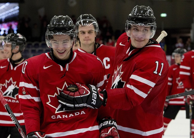 Canada's Charles Hudon (10) and Bo Horvat (11) celebrate as they skate off the ice after defeating the USA 3-2 at the IIHF World Junior Hockey Championships in Malmo, Sweden on Tuesday December 31, 2013. THE CANADIAN PRESS/ Frank Gunn.